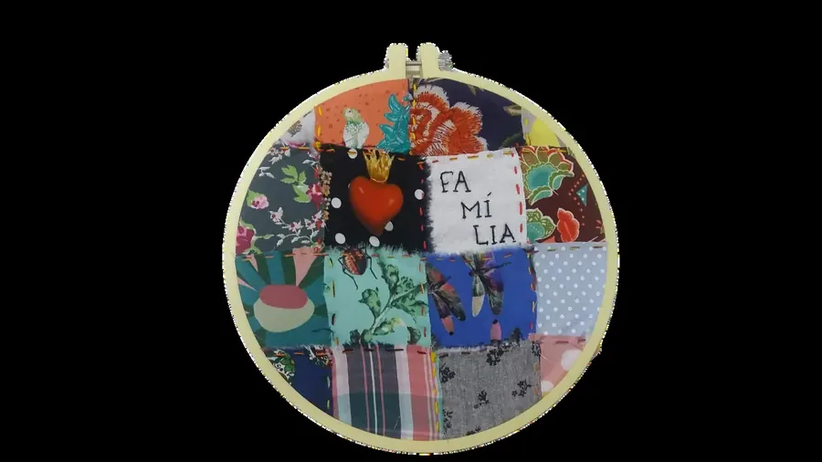 Bastidor com colcha de retalhos bordada com a palavra família